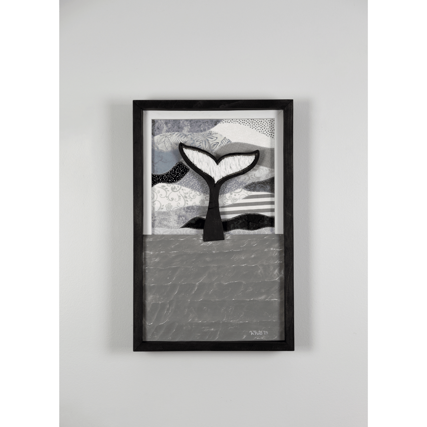 Shop for Newfoundland driftwood art at The White's Emporium. This mixed-media piece shows a whale tail diving into the water against a quilted fabric sky.