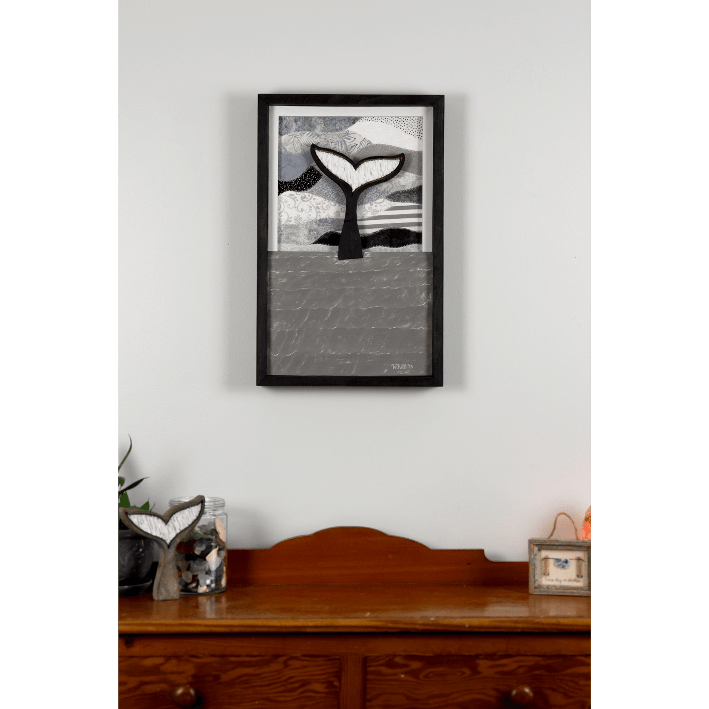 Shop for Newfoundland driftwood art at The White's Emporium. This mixed-media piece shows a whale tail diving into the water against a quilted fabric sky.