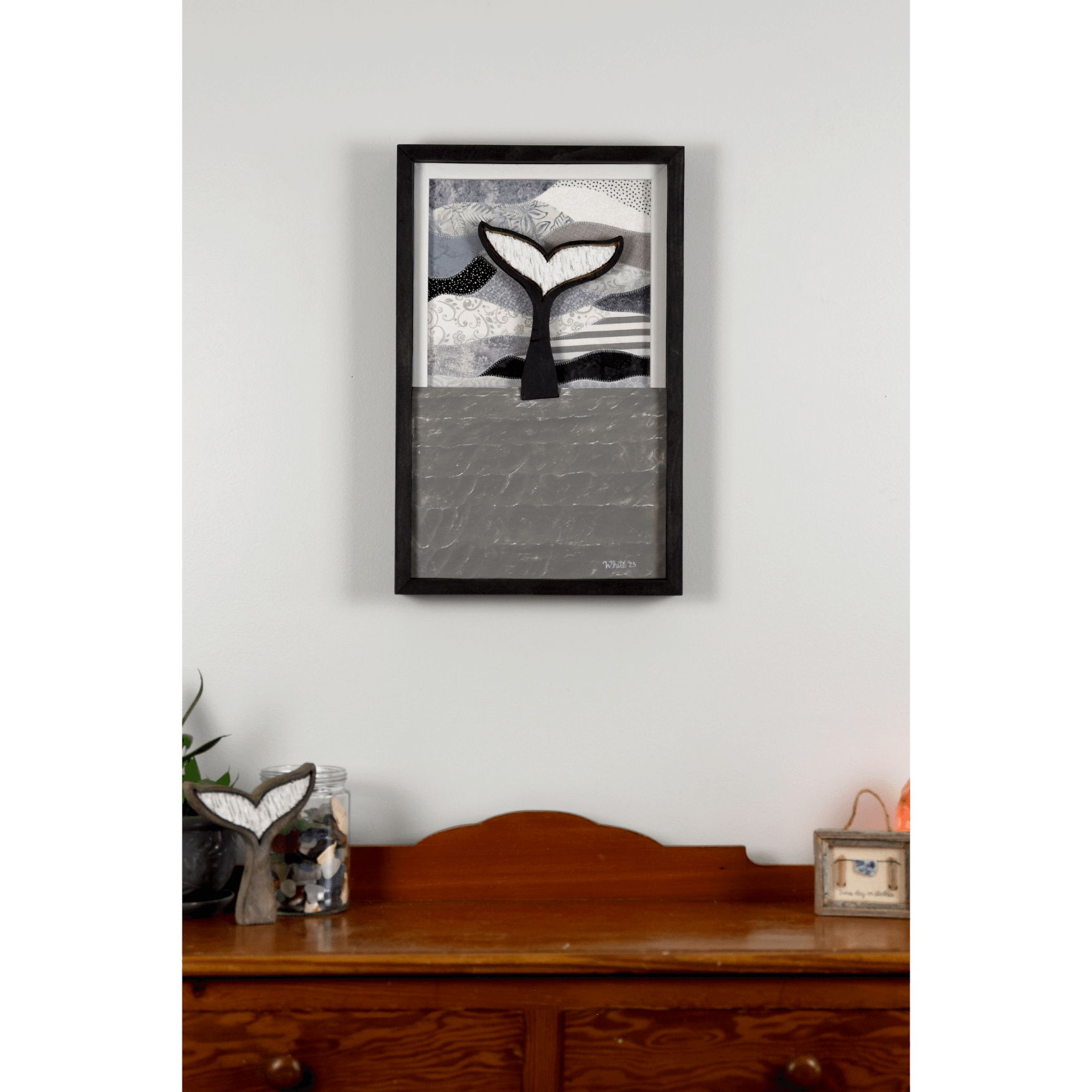 Shop for Newfoundland driftwood art at The White's Emporium. This mixed-media piece shows a whale tail diving into the water against a quilted fabric sky.