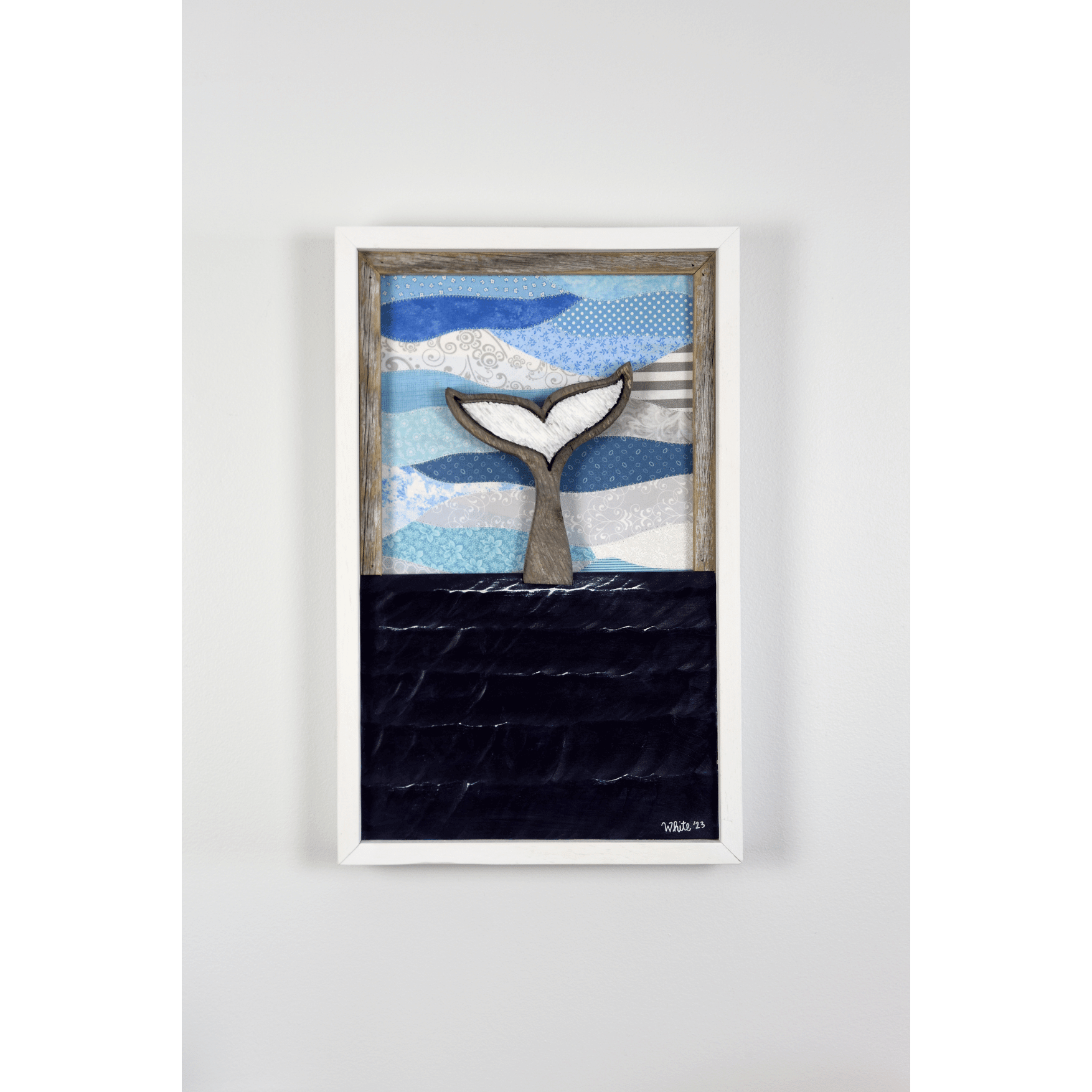 Shop for Newfoundland driftwood art at The White's Emporium. This mixed-media piece shows a whale tail diving into the water against a quilted fabric sky.