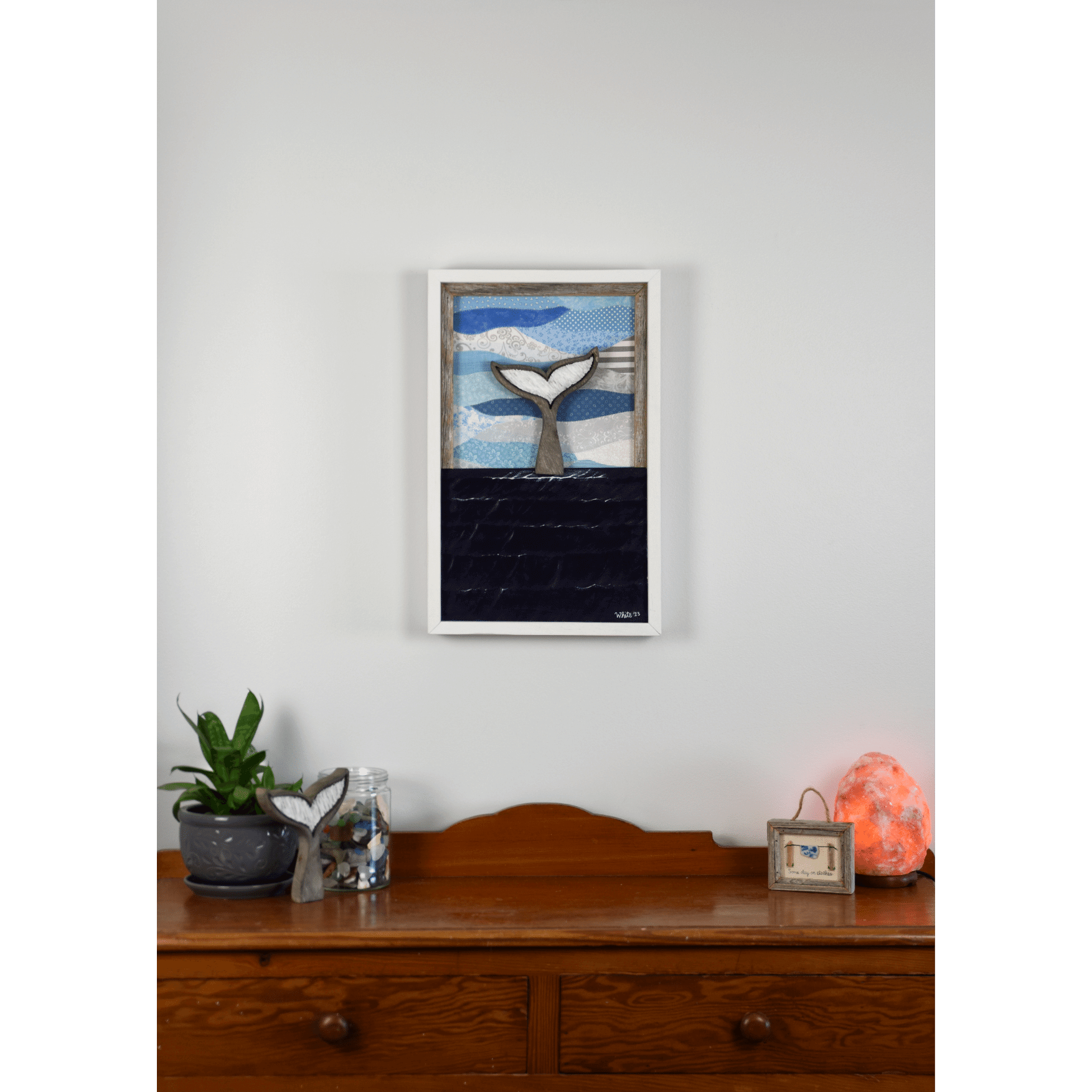 Shop for Newfoundland driftwood art at The White's Emporium. This mixed-media piece shows a whale tail diving into the water against a quilted fabric sky.