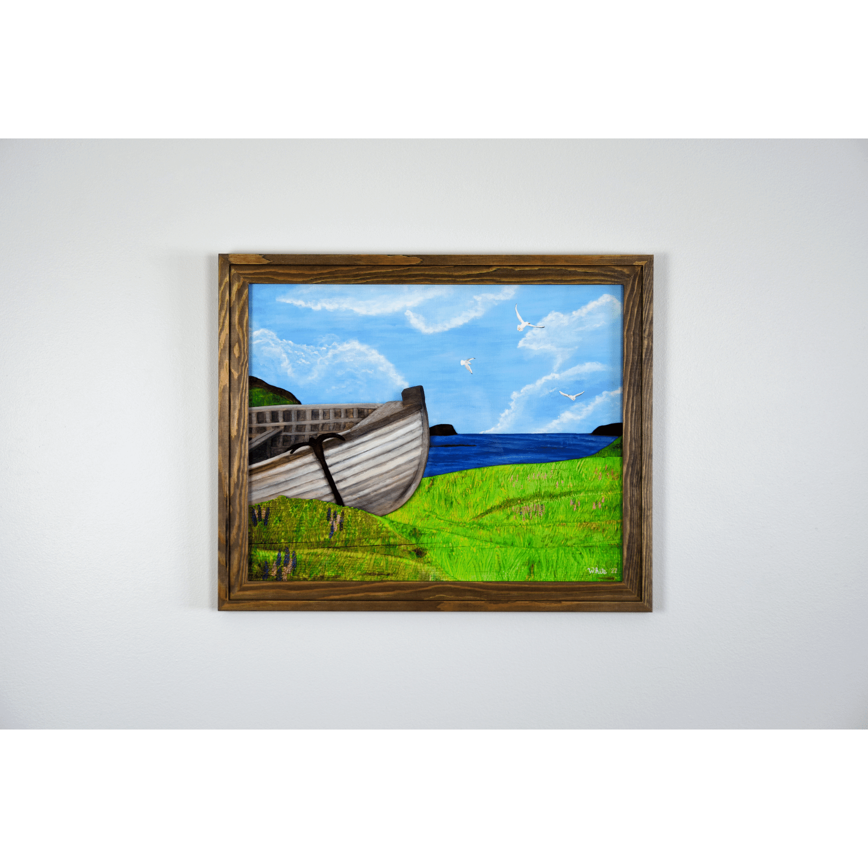 "New Beginnings" is a print featuring a wooden fishing boat that sits on a green Newfoundland shore with the ocean and seagulls in the background.