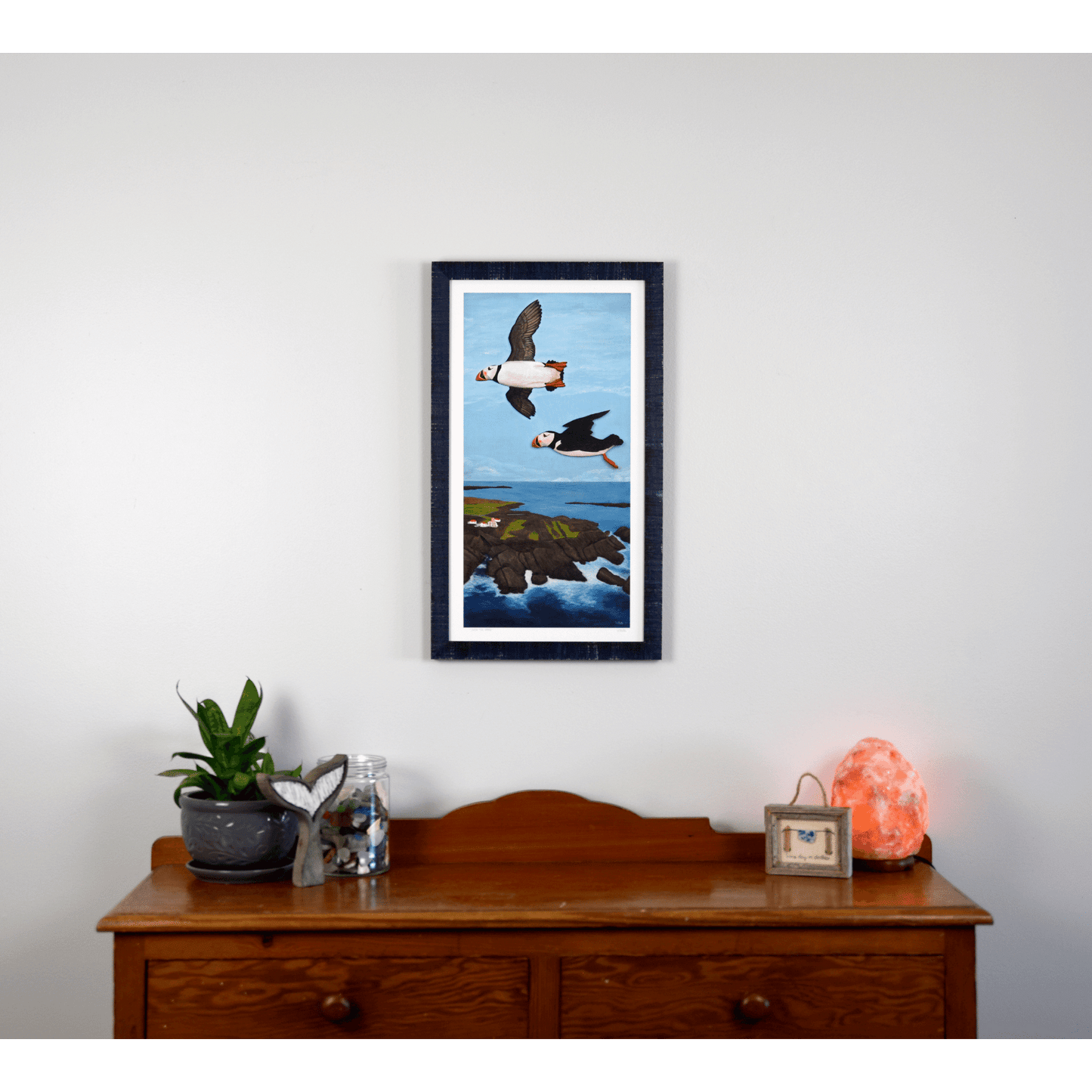"Over the Cape" reproduction print showcases two puffins flying over the rugged Newfoundland coast.