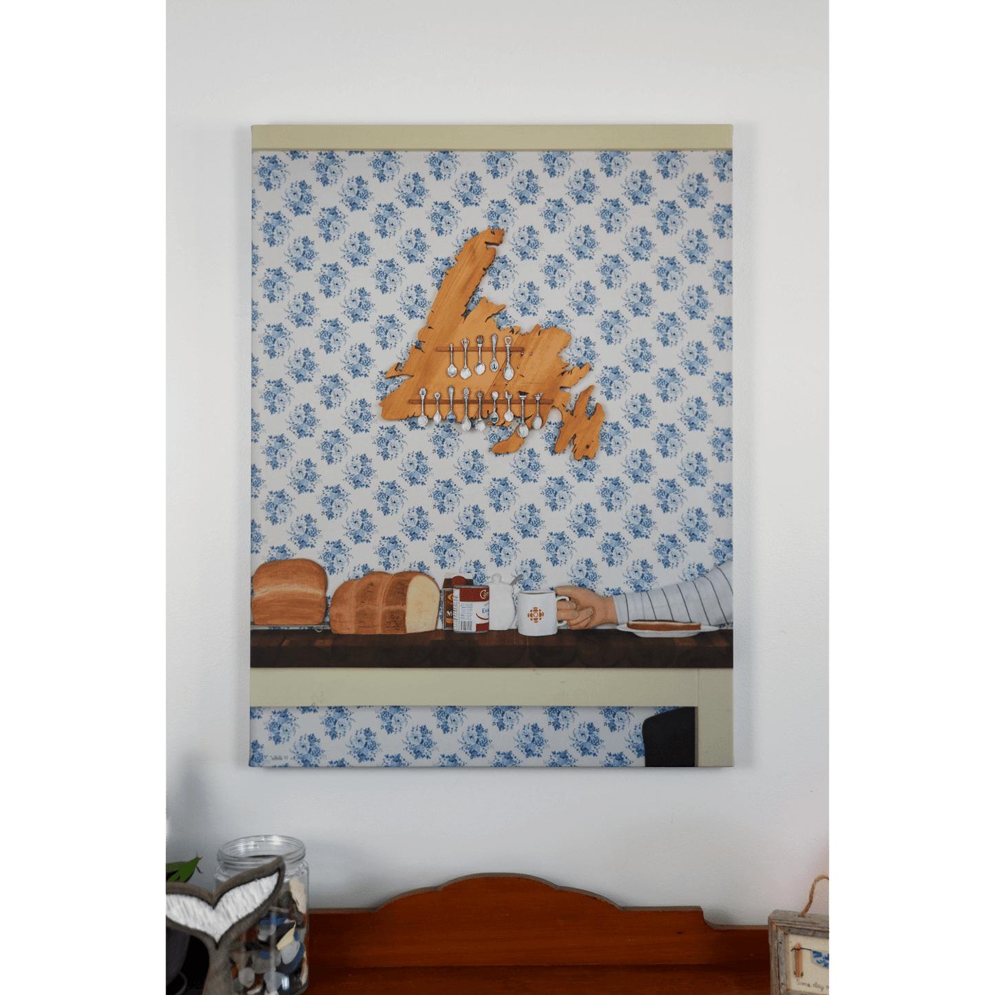 "Stealing the Healtap" canvas print that captures the warmth of a cozy family meal at Nan's, with bread, a mug, and a wooden spoon holder shaped like Newfoundland.