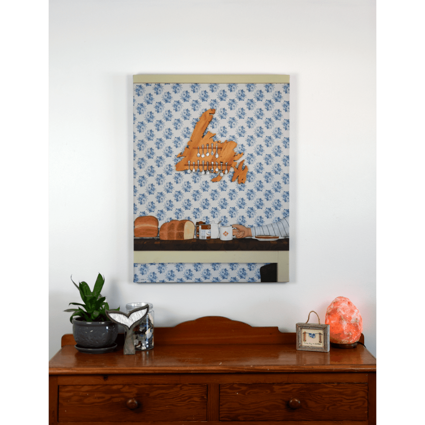 "Stealing the Healtap" canvas print that captures the warmth of a cozy family meal at Nan's, with bread, a mug, and a wooden spoon holder shaped like Newfoundland.
