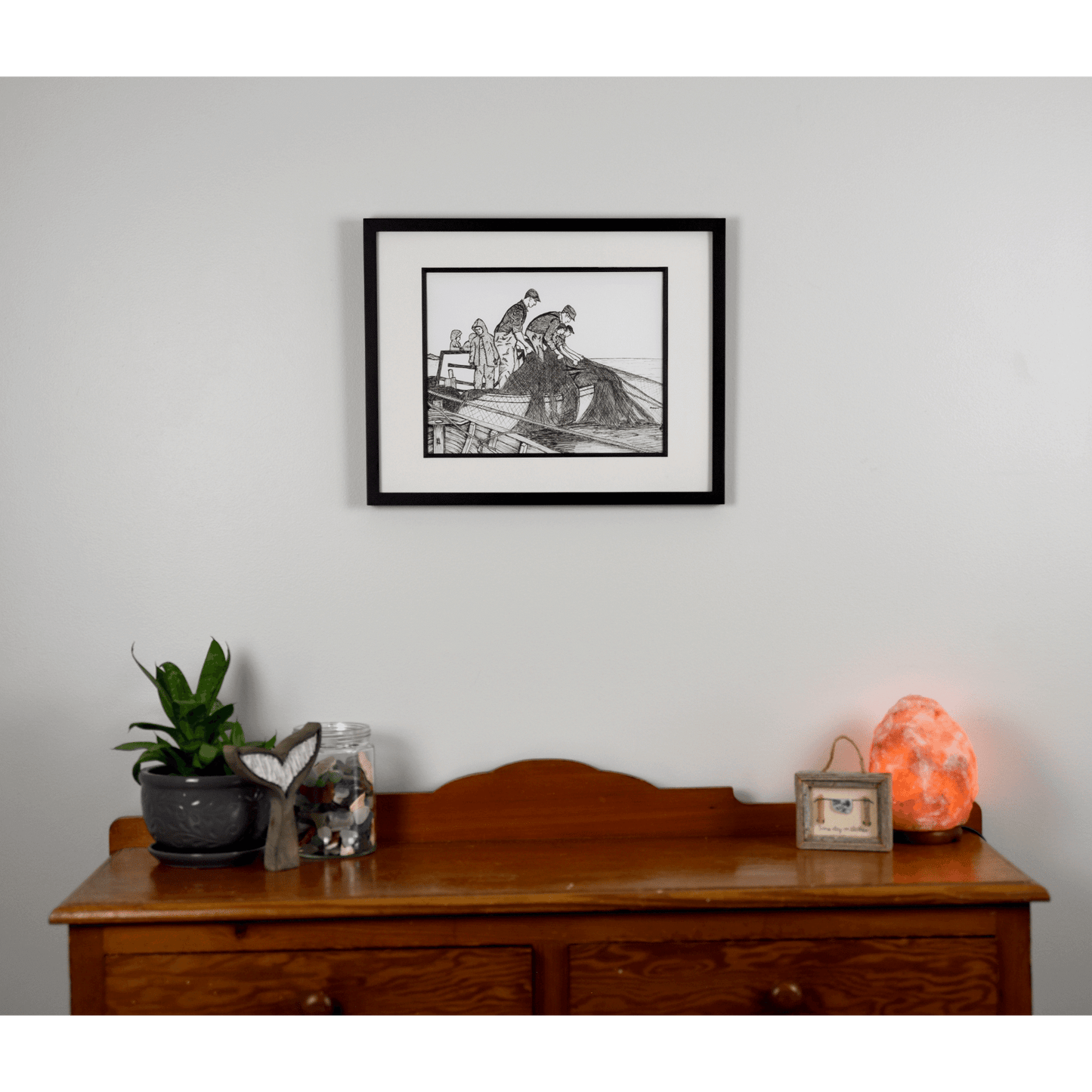 Add a touch of rustic charm with "The Haul" reproduction print. This pen and ink print features fishermen hauling their nets to the boat.