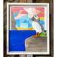 "Spring Views" is an original driftwood mixed-media art piece that captures a puffin standing on a rock over looking the water. 