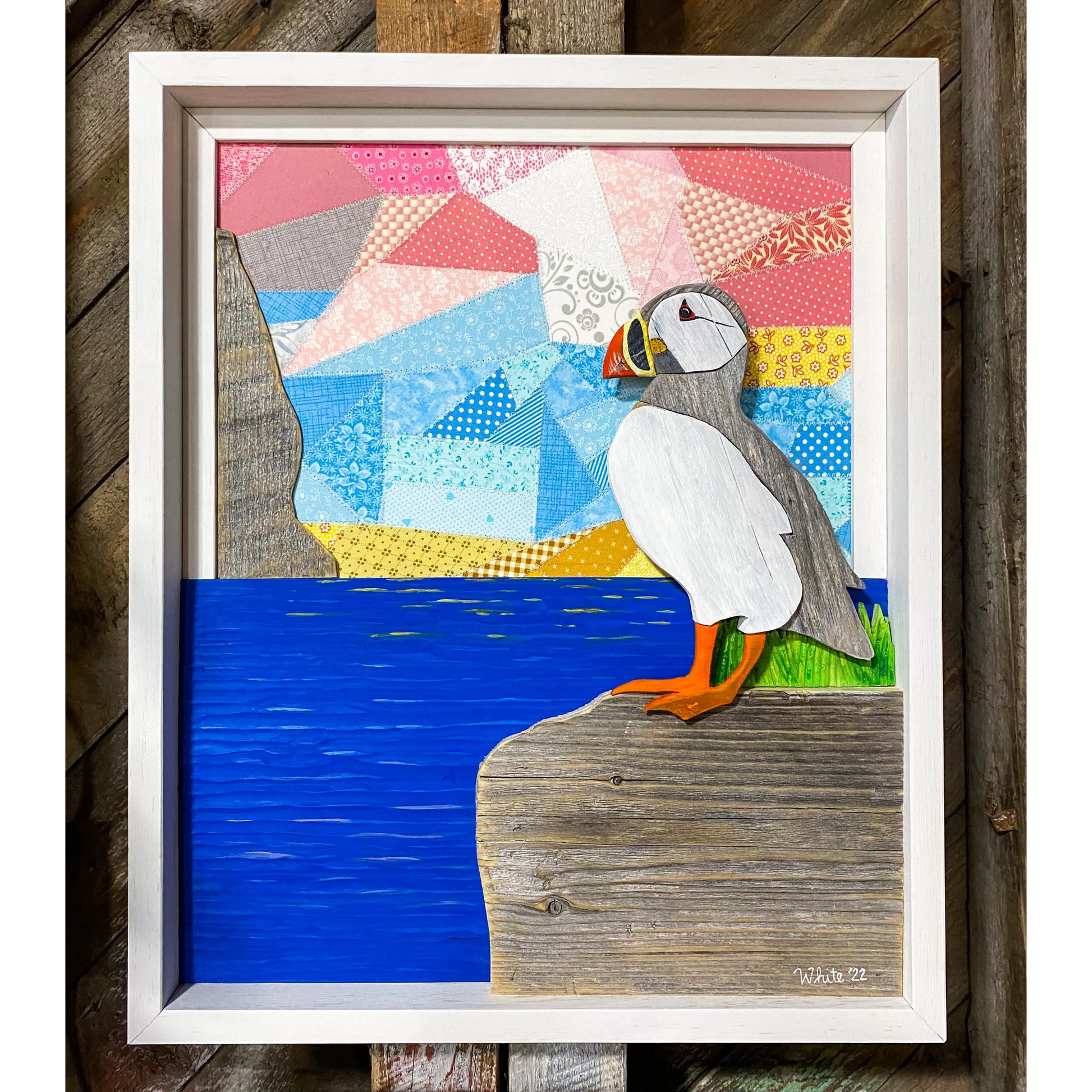 "Spring Views" is an original driftwood mixed-media art piece that captures a puffin standing on a rock over looking the water. 