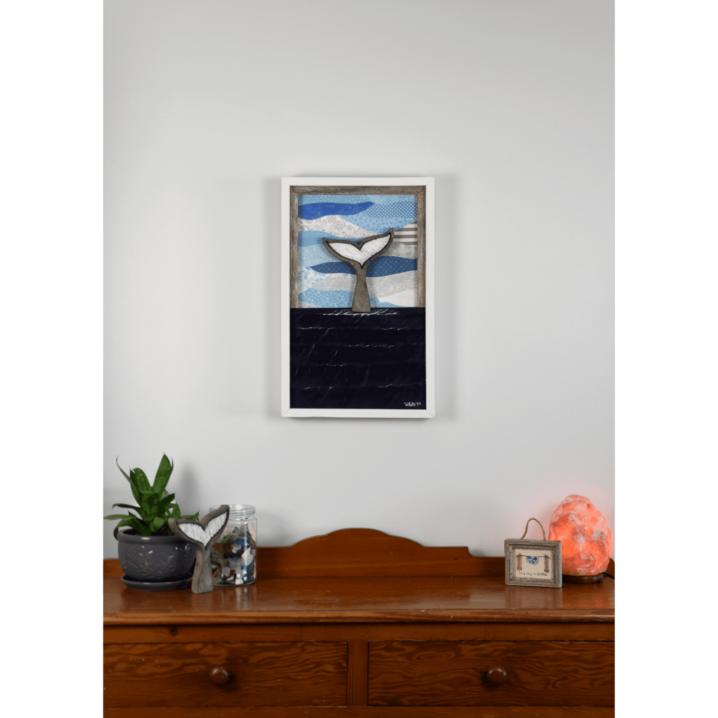 Shop for Newfoundland driftwood art at The White's Emporium. This mixed-media piece shows a whale tail diving into the water against a quilted fabric sky.