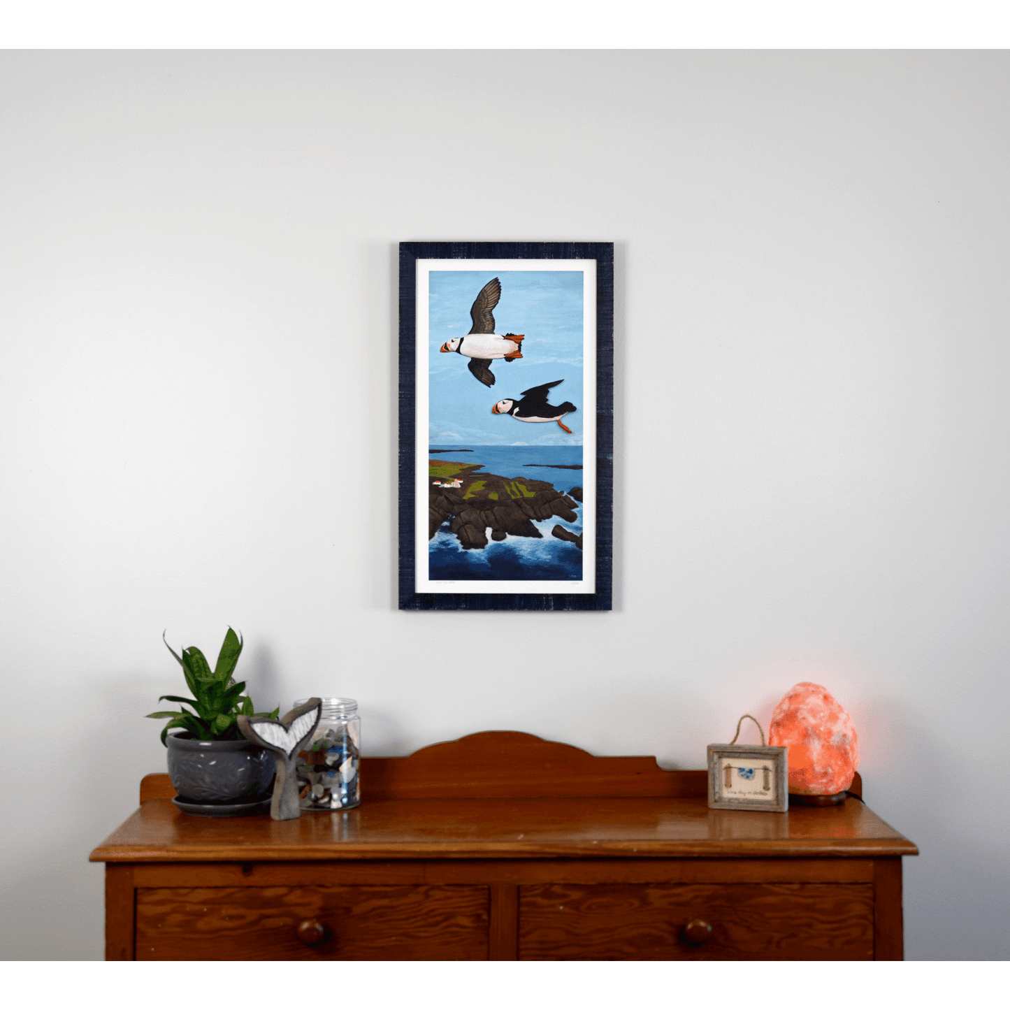  "Over the Cape" reproduction print showcases two puffins flying over the rugged Newfoundland coast.