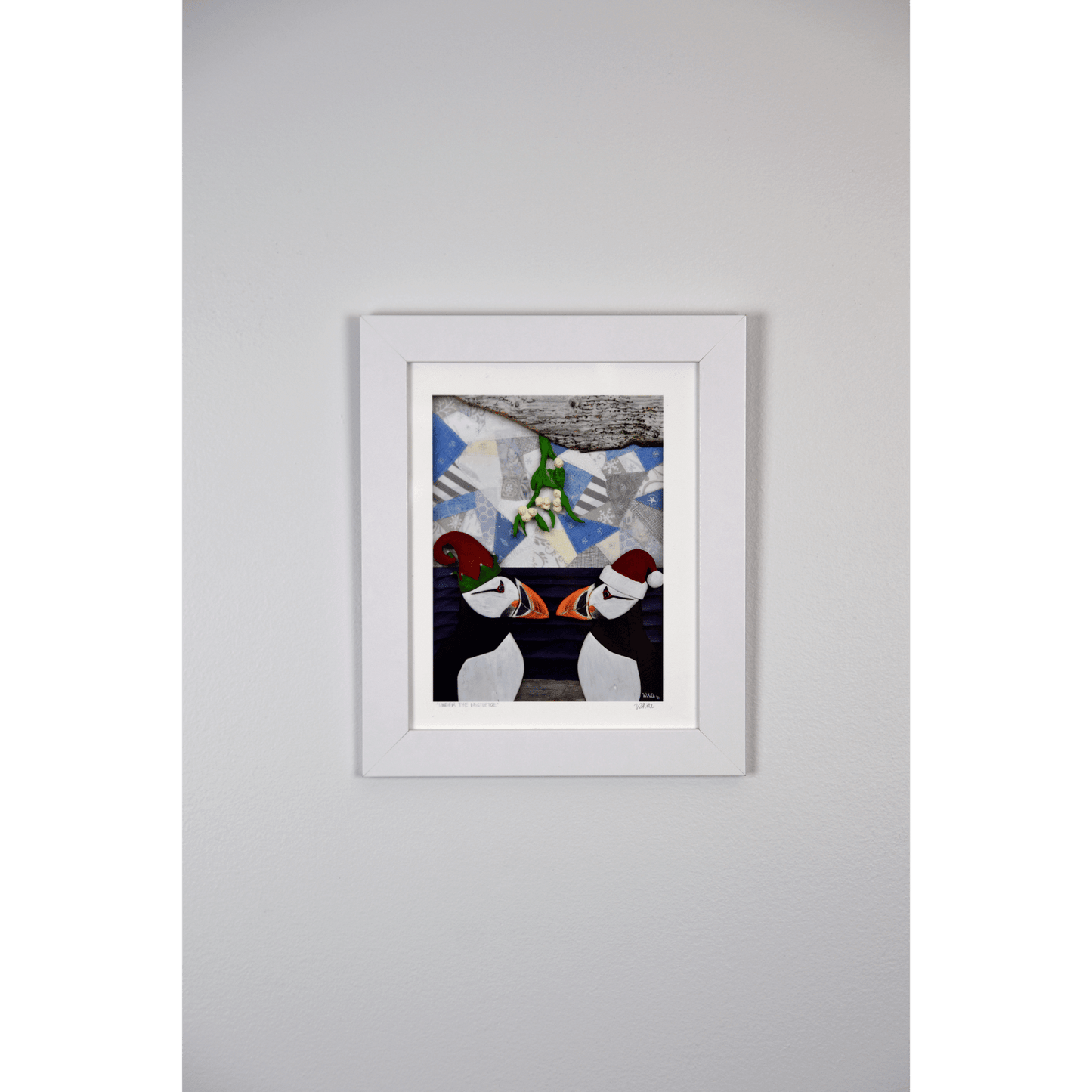  Add a playful touch to your holiday decor with our "Under the Mistletoe" print. It features 2 charming puffins in Santa and Elf hats, kissing under a mistletoe.